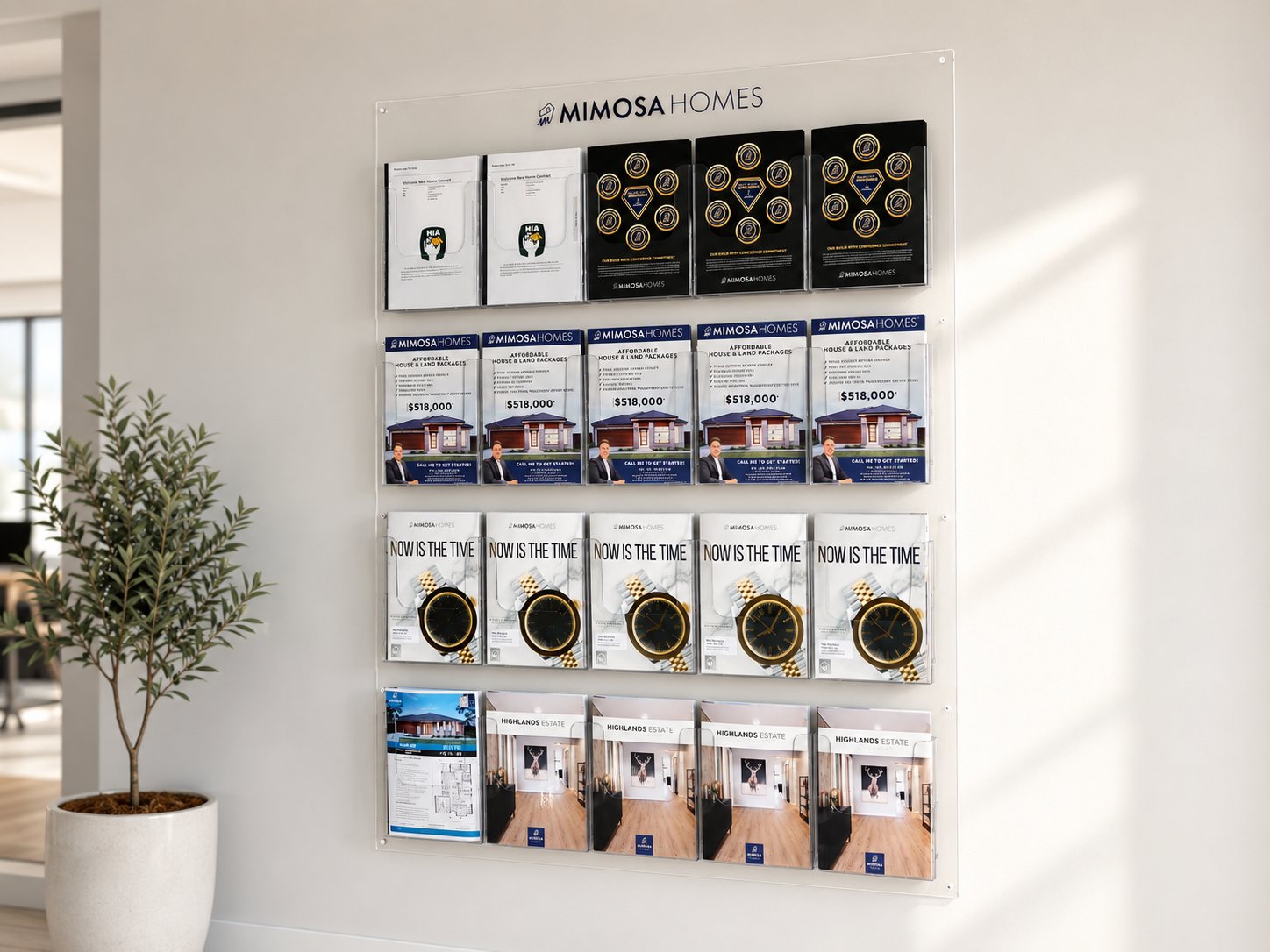 Wall-mounted clear acrylic brochure display with a logo header